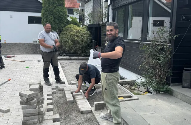 Fagfolk legger lys belegningsstein foran inngangen til en bolig